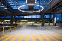 an empty parking garage with circular lights on it at dusk or dusk as well as parking meters and several barriers