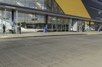 this is the front side of an airport building showing its passengers entering and exiting from