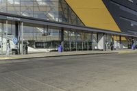 this is the front side of an airport building showing its passengers entering and exiting from