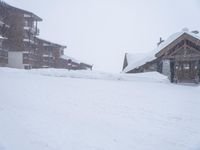 a wooden cabin and snow covered road in a neighborhood on a cold winter day in winter