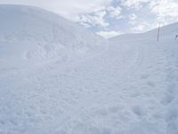 a man riding a snowboard down a snow covered slope on a ski slope on skis