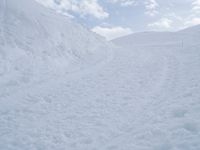 a man riding a snowboard down a snow covered slope on a ski slope on skis