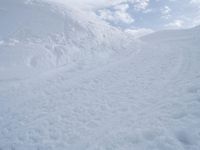 a man riding a snowboard down a snow covered slope on a ski slope on skis