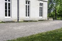 the building is a stone with three large windows on it and benches in front of it