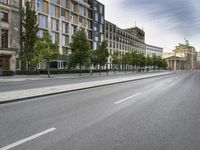 an empty street lined with tall buildings near the city hall in brussels, france, on a cloudy day