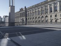 a clock tower near some buildings on a sunny day, behind a railing that says town hall