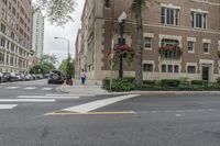 a town intersection with buildings, trees and white lines on the street with a red fire hydrant