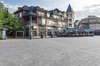 the town plaza is lined with old houses and buildings with open streets and tables for seating