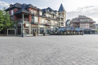 the town plaza is lined with old houses and buildings with open streets and tables for seating