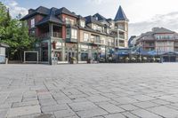 the town plaza is lined with old houses and buildings with open streets and tables for seating