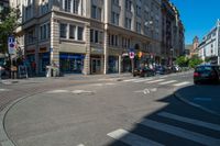 a town street with a stoplight and people walking on the sidewalk and parked cars