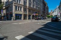 a town street with a stoplight and people walking on the sidewalk and parked cars