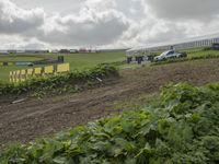 this is an image of a tractor plowing a field at a farm near houses