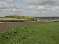 this is an image of a tractor plowing a field at a farm near houses