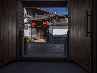 a door opens into a courtyard with traditional style buildings in china's xi'an