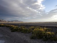 a train is coming down the track with mountains in the distance and a mountain range in the background