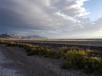 a train is coming down the track with mountains in the distance and a mountain range in the background