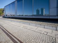 a train tracks that are next to a glass wall in a building with a city skyline in the background