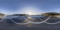 the circular lens panoramic view shows the empty parking lot at a train station