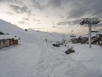 the ski lift is above all snow in the village, but no people are traveling