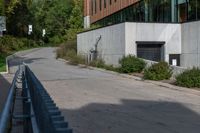 the sidewalk along this side of a building in a city with concrete walls and columns