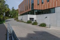 the sidewalk along this side of a building in a city with concrete walls and columns