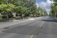 empty city street with no traffic, and tree lined roadway in the background for no pedestrians to make it