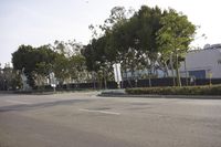 a street is lined with trees in front of a warehouse building that's opposite side