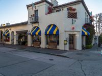 a very colorful looking building with lots of windows and awnings in it's corner