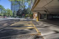 a empty parking lot is near some large buildings and trees with skyscrapers in the background