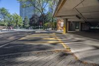 a empty parking lot is near some large buildings and trees with skyscrapers in the background