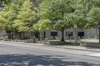 a city street filled with lots of trees and shrubs near a sidewalk lined with benches