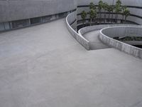 a building with cement roof near green grass and lawn in front of it, under a gray sky