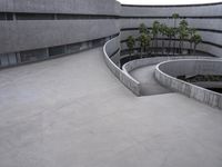 a building with cement roof near green grass and lawn in front of it, under a gray sky