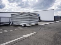 the large truck is parked in a parking lot with its door open and the sky above