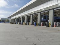 a truck repair shop with yellow line paint and some trash cans and containers in front