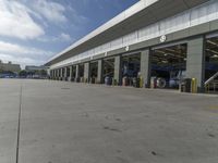 a truck repair shop with yellow line paint and some trash cans and containers in front