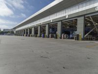 a truck repair shop with yellow line paint and some trash cans and containers in front