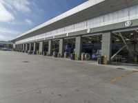 a truck repair shop with yellow line paint and some trash cans and containers in front