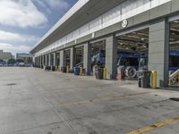 a truck repair shop with yellow line paint and some trash cans and containers in front