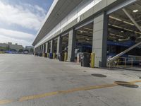 a truck repair shop with yellow line paint and some trash cans and containers in front