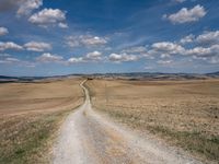 Exploring the Tuscan Countryside: A Dirt Road Amidst Rugged Landscape