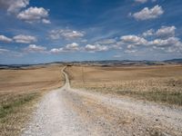 Exploring the Tuscan Countryside: A Dirt Road Amidst Rugged Landscape