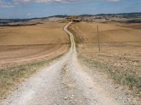 Exploring the Tuscan Countryside: A Dirt Road Amidst Rugged Landscape