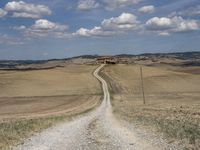 Exploring the Tuscan Countryside: A Dirt Road Amidst Rugged Landscape