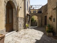 a view of a side street in the town center with stone buildings and an archway above it