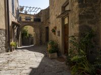 a view of a side street in the town center with stone buildings and an archway above it