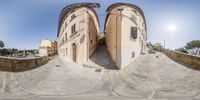 two buildings that have identical faces and are in the same photo above a street way