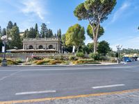 a beautiful place to live with people sitting and walking next to the road at the curb