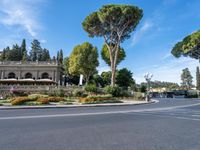 a beautiful place to live with people sitting and walking next to the road at the curb